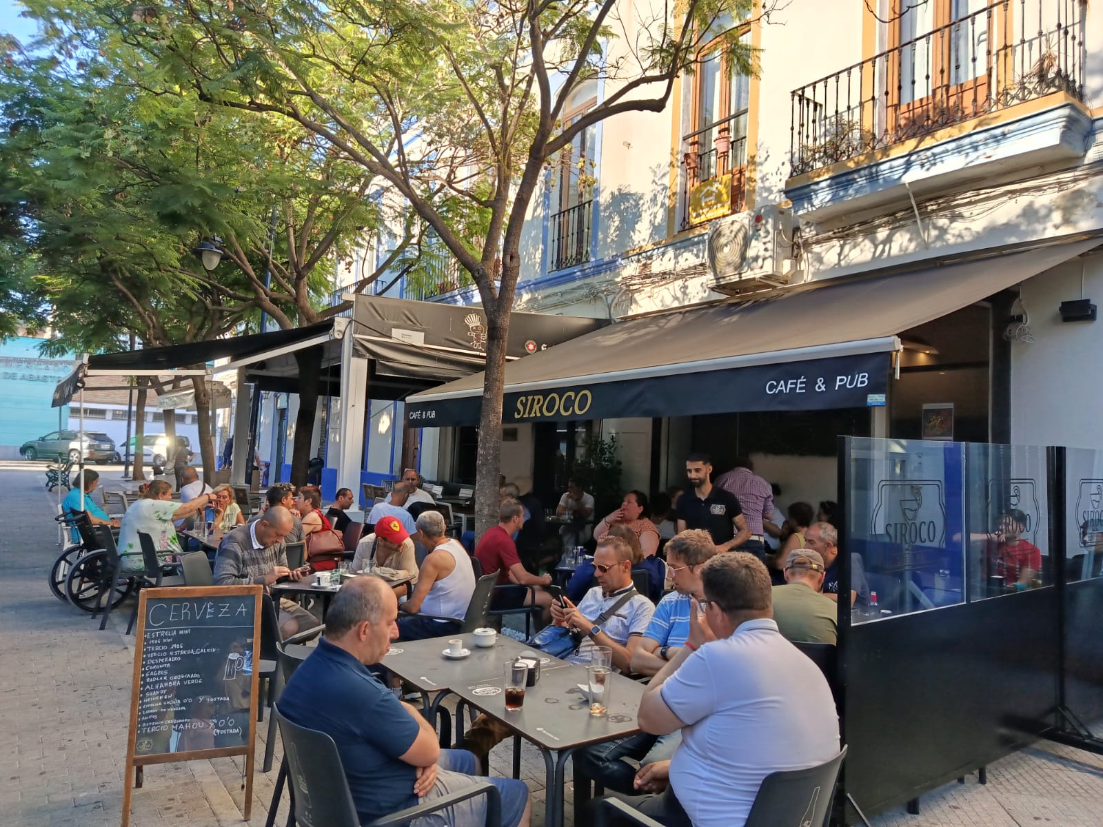 Ambiente nocturno del Siroco Café Pub con clientes y luces cálidas